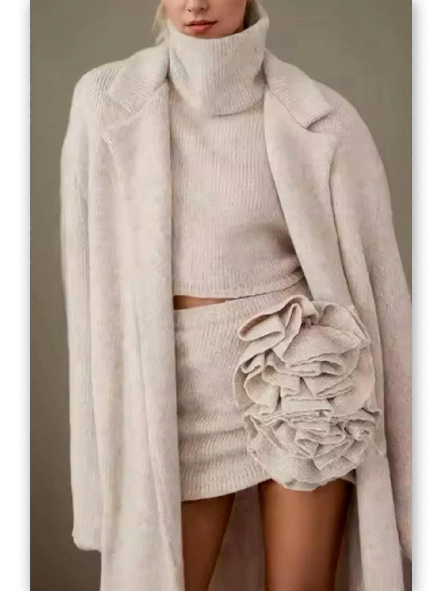 Cozy knitwear ensemble featuring a sleeveless turtleneck and flower applique skirt