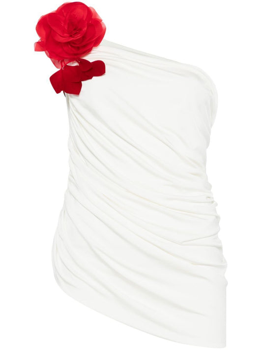 White one-shoulder dress with red floral embellishment and detachable rose brooch