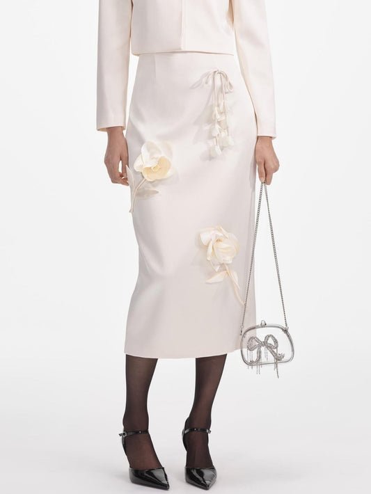 Woman wearing a floral-applique cream midi pencil skirt in stylish ensemble