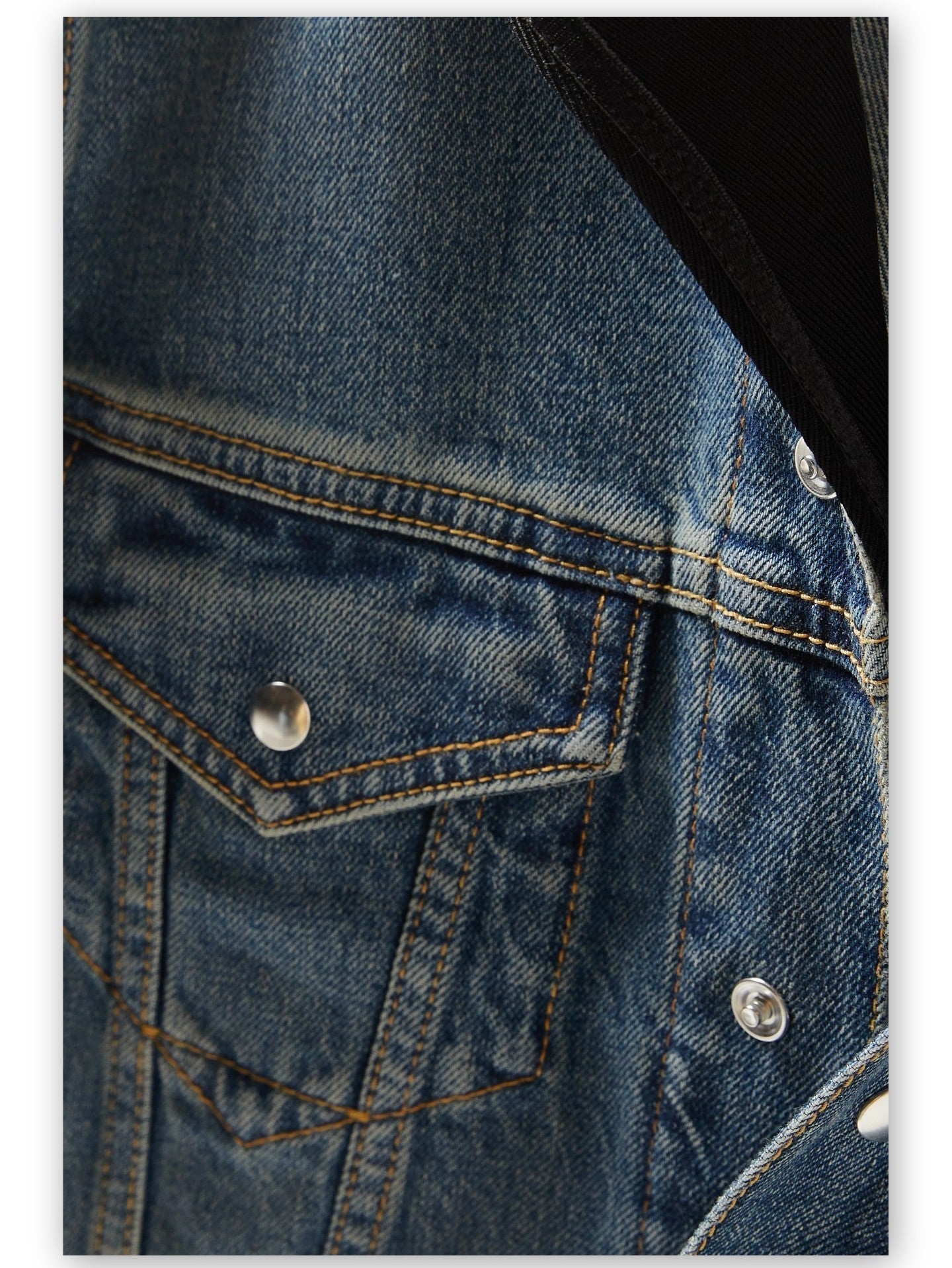 Detail of a Hooded Jersey-Trimmed Denim Jacket showcasing blue denim fabric texture
