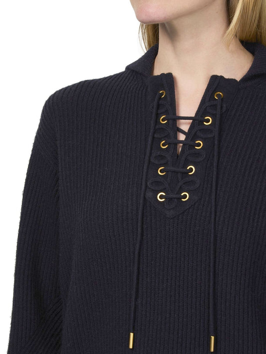 Navy knit sweater featuring ribbed eyelet and lace-up detail for a stylish look