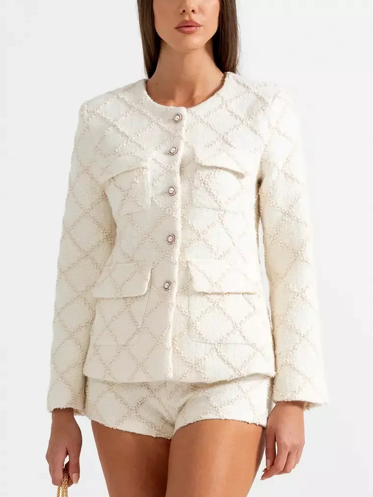 White textured tweed jacket and matching short set displayed on a model