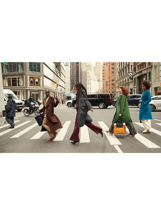People crossing city street in colorful winter coats inspired by Abbey Road style.