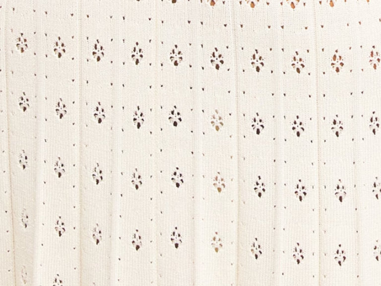 Sleeveless cream dress with bead-embellished details, a stylish drop-waist knit pleated midi