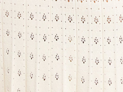 Sleeveless cream dress with bead-embellished details, a stylish drop-waist knit pleated midi