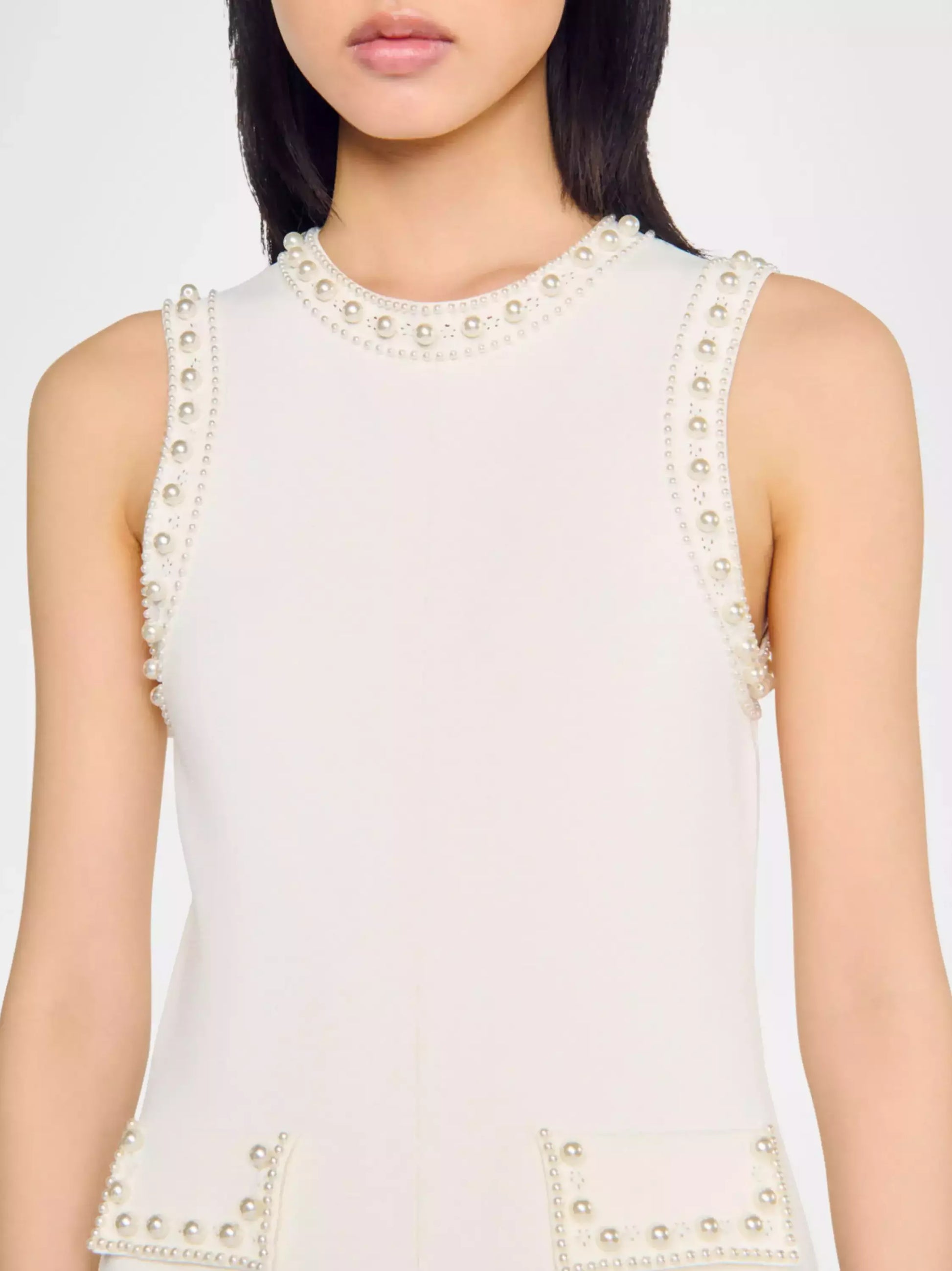 Sleeveless cream dress with embellishments, perfect for bead-embellished drop-waist knit style