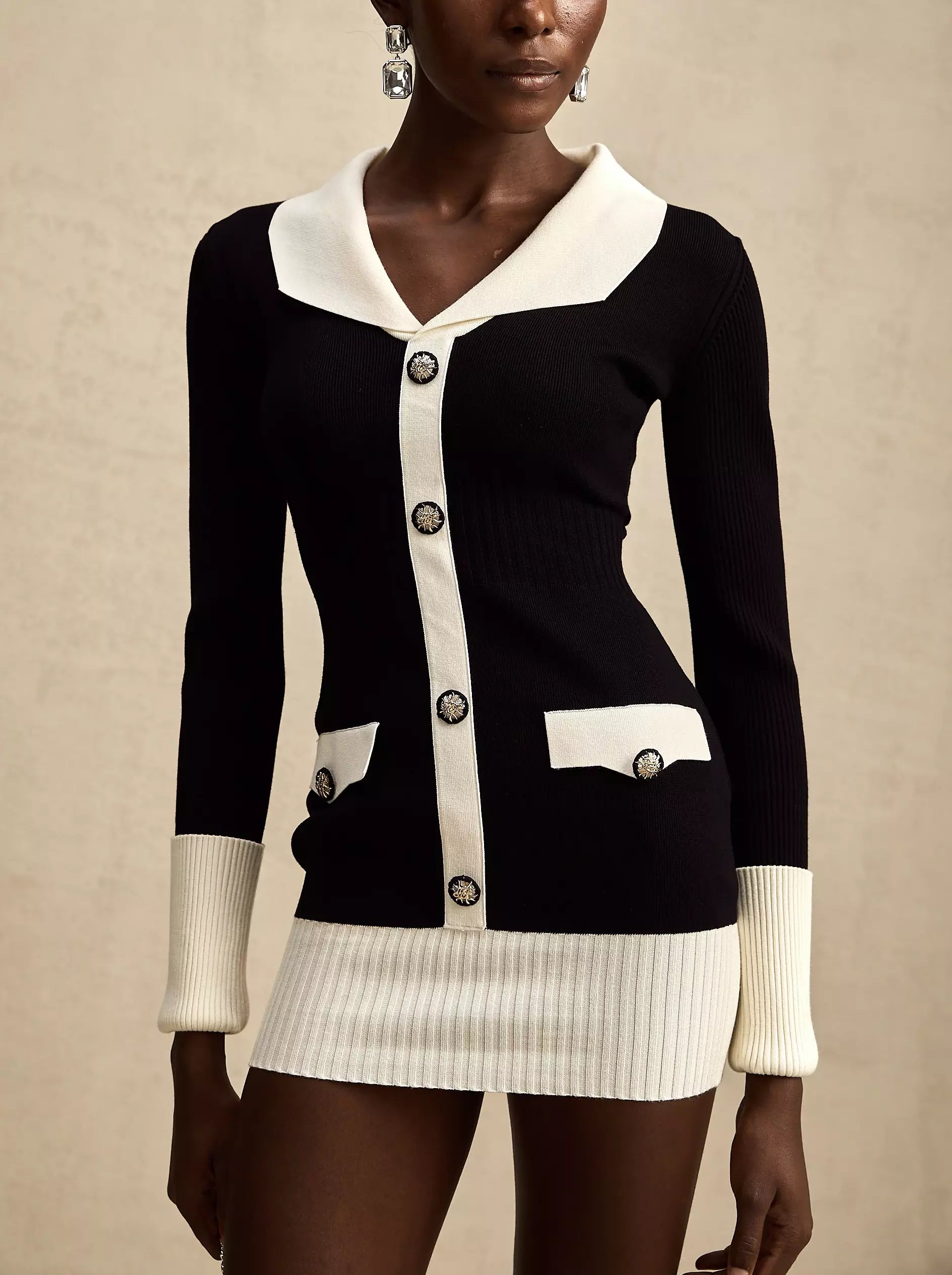 Black and white bicolor ribbed knit mini sweater dress with buttons stylishly displayed