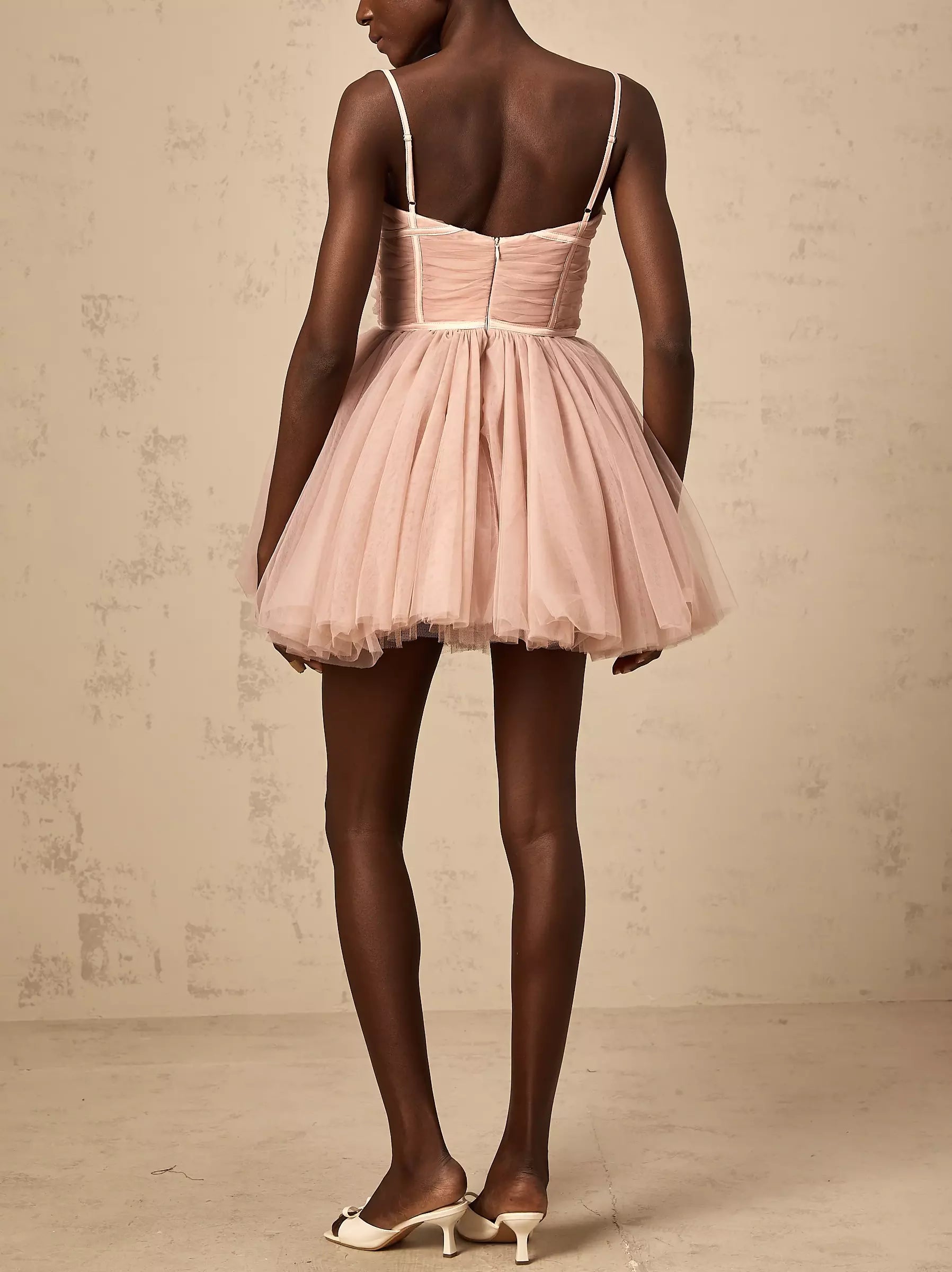 Short pink tulle flared mini dress with bow-detail sleeveless design for playful style