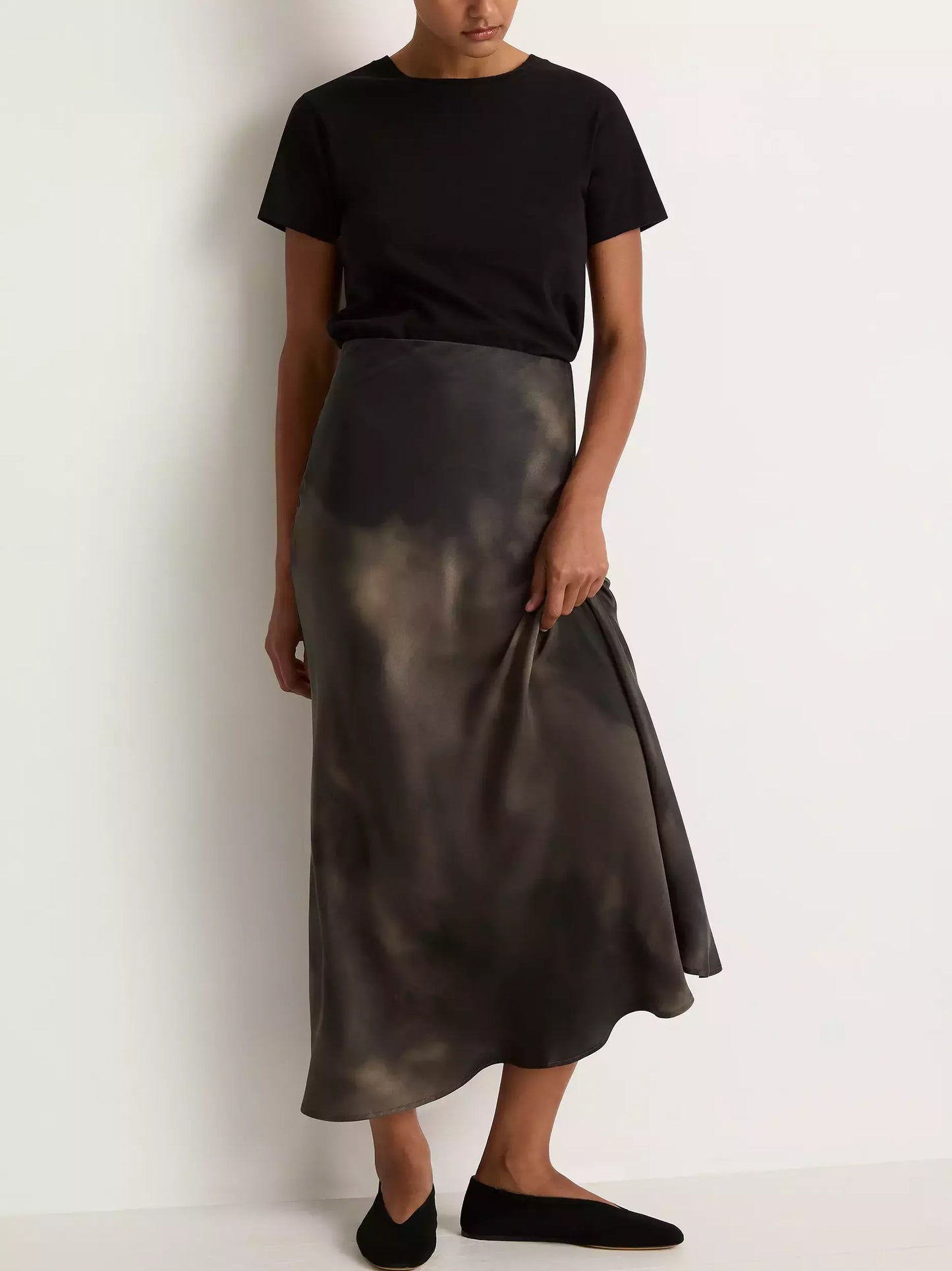 Woman in a black t-shirt showcasing a Silk Sand-Washed Long Skirt with tie-dye design