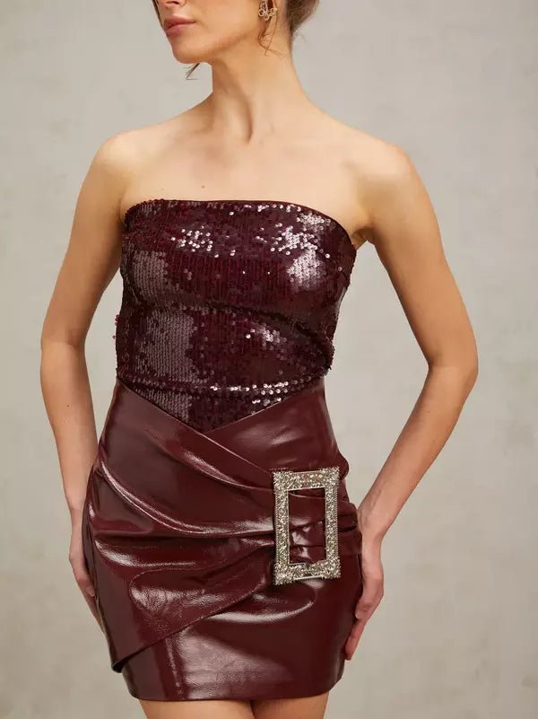 Burgundy strapless sequin mini dress with buckled wrap effect and faux leather skirt