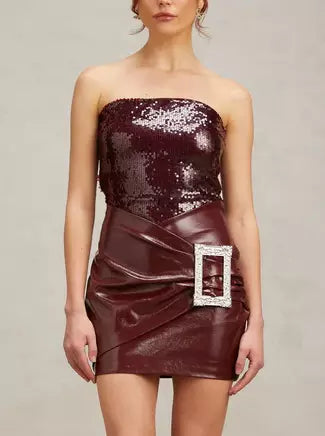Burgundy strapless sequin mini dress with buckled wrap effect and faux leather skirt